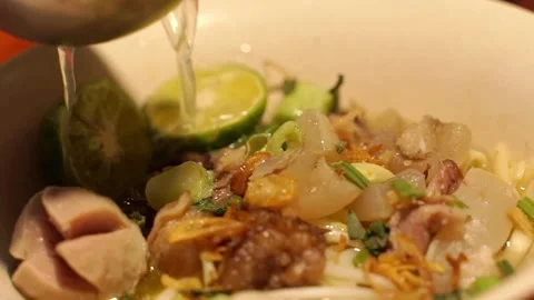 Pour the broth into the bowl containing the typical Bnadung whipped noodles Stock Footage 270347206