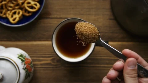 Pour cane sugar from spoon into cup of tea Stock Footage 106145365