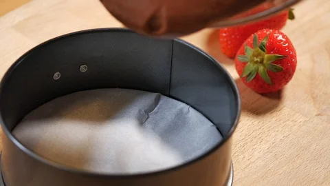 Pour chocolate mixture into the cake tin. making pastry chocolate cake Stock Footage 111631301