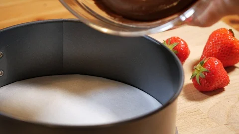 Pour chocolate mixture into the cake tin. making pastry chocolate cake Stock Footage 111631915