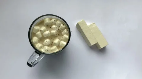 Pour cinnamon on coffee with marshmallows. Stock Footage 131745275
