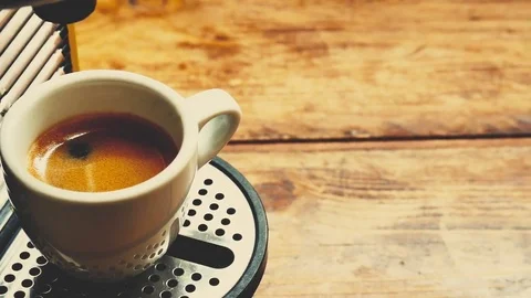 Pour coffee with coffee maker in a white cup on a wooden table in the kitchen at Stock Footage 74069621