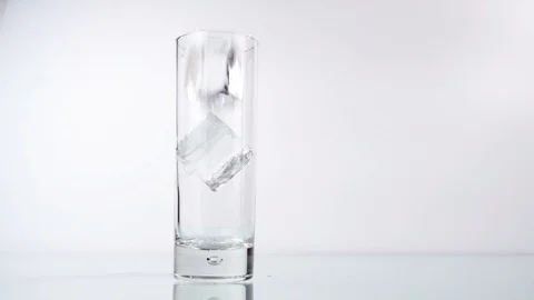 Pour Cola out of a Bottle in a Glass with clear Ice Cubes Stock Footage 123718943