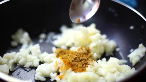 To pour Cooking powders into smashed potatoes in the fry pan Stock Footage 143593720