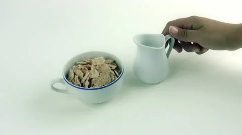 To pour in a cup of milk and cereal for breakfast Stock-Footage 12745751