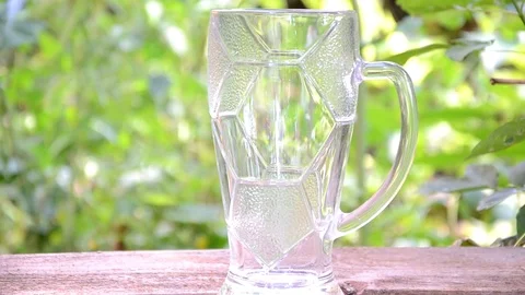 Pour dark beer on a background of green foliage Stock Footage 83732241