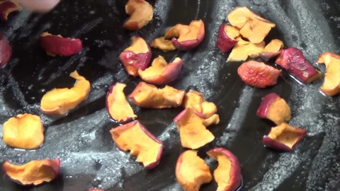 Pour dried apple pieces onto a baking dish. Oiled frying pan Stock Footage 182315817