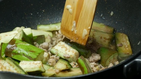 Pour drinking water into the black teflon pan. Stir fried  green sliced piece Stock Footage 89445899