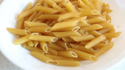 Pour dry pasta into a dish. Stock Footage 345639972