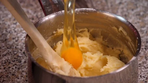 Pour egg into the pot for choux pastry preparation - slow motion Stock Footage 98179949