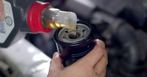 Pour engine oil into the oil filter. Change the oil filter. Car maintenance Stock Footage 267274197