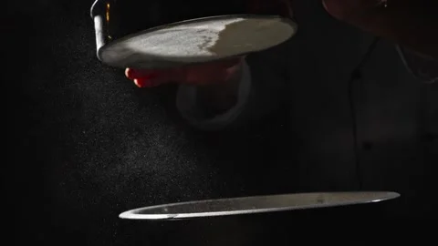 Pour the flour for the dough through a sieve over a dark background. Baking and Stock Footage 264401294