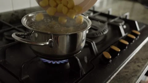 Pour gnocchi into a pot of boiling water Stock Footage 314858546