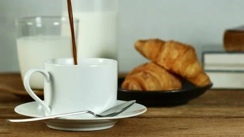 Pour hot coffee into a white coffee cup on old wooden table. Stock Footage 151490011