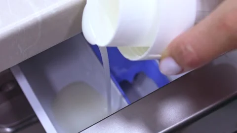 Pour laundry detergent gel into the washing machine container Stock Footage 257123710