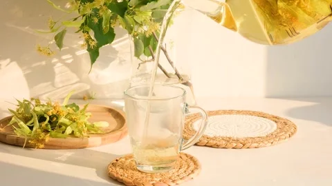 Pour linden tea into a transparent cup Stock Footage 256606540
