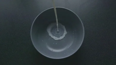 Pour milk into a bowl in slow motion Stock Footage 57638853