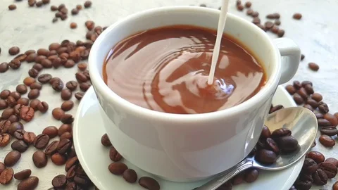 Pour milk into a cup of coffee Stock Footage 117412022