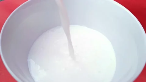 Pour the milk into the Cup, red background. Stock Footage 160668281