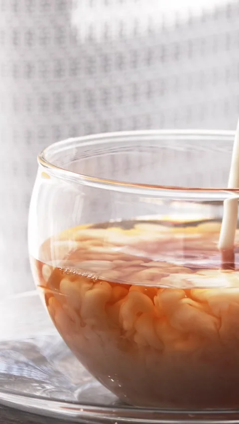 Pour milk into hot tea Stock Footage 331227839