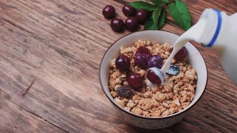 Pour the milk into the muesli Stock Footage 243572448