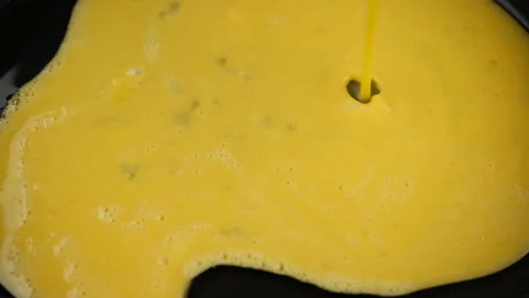 Pour mixed eggs in pan for cooking omelette Stock-Footage 235671474
