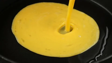 Pour mixed eggs in pan for cooking omelette Stock Footage 236286160