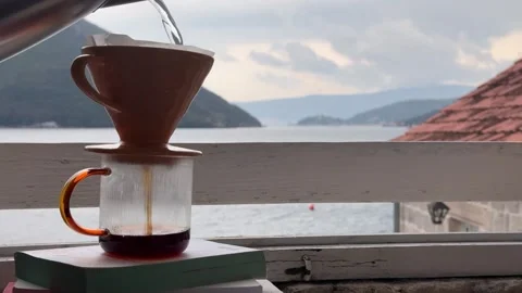 Pour Over Coffee Brewing by Seaside Window with Mountain View Stock Footage 335875911