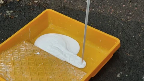 Pour paint into the roller paint distribution tray Stock Footage 306152932