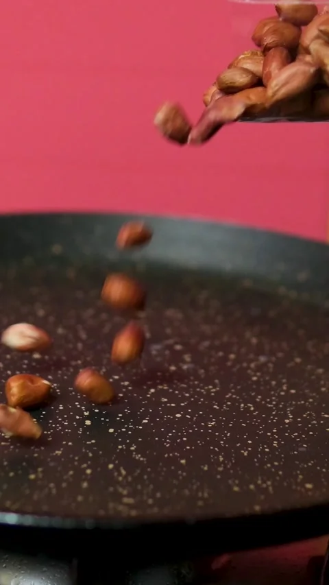 Pour peanuts into the pan Cooking crispy roasted salted peanuts. Nuts beans Stock Footage 305980572