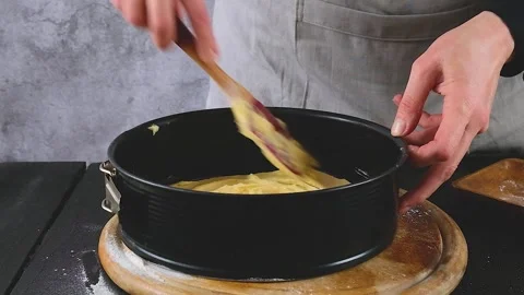 Pour the prepared dough into a cake mold. Making a sweet cake Stock Footage 259516645