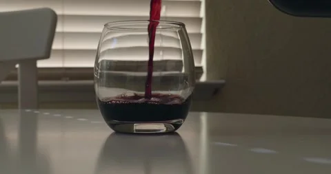 Pour red wind in stemless glass with a window in the background Stock Footage 311034949