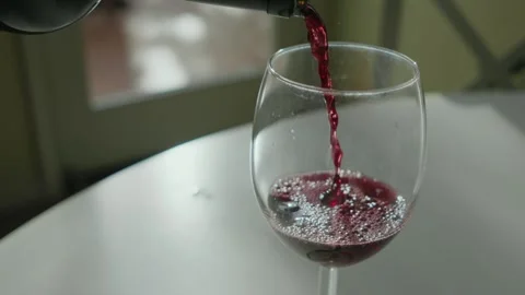 Pour red wine into glass on table with soft light Stock Footage 292179356