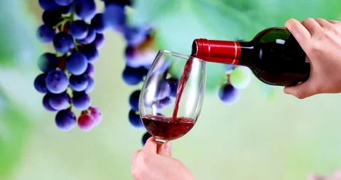 Pour red wine into transparent goblet on airplane and in vineyard. Video stock 124274758