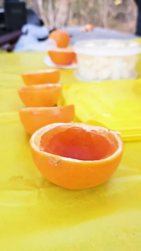 Pour rum into a makeshift glass - a tangerine hemisphere Stock Footage 298024237