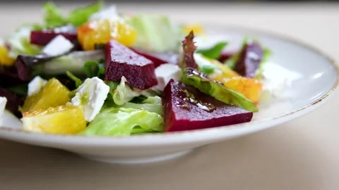 Pour sauce over Beetroot salad greens Eating Beetroot salad with feta cheese and Stock Footage 320823451