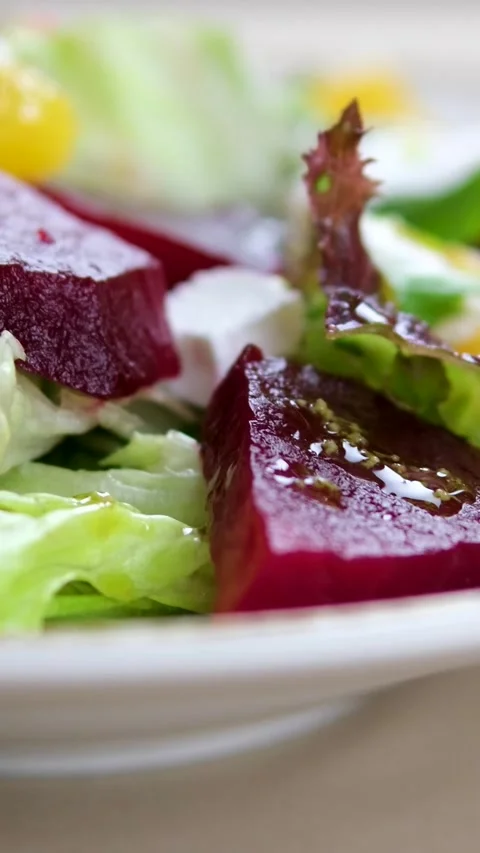 Pour sauce over Beetroot salad greens Eating Beetroot salad with feta cheese and Stock Footage 323526420
