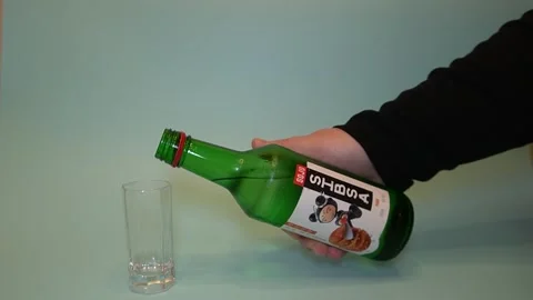 Pour the soju into an empty glass. The glass is taken out of the frame. Stock Footage 320145986