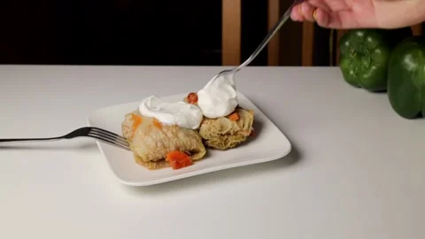Pour sour cream over cabbage rolls that are on the table Stock Footage 280649787