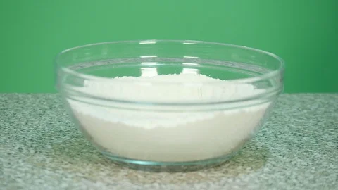 Pour vegetable milk into flour to prepare dough for baked goods - green scree Stock Footage 126612330