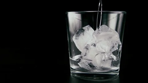 Pour vodka into the ice. Slow mo Video stock 76434422