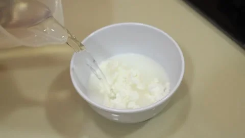 Pour water into the flour mixture. Stock Footage 334647448