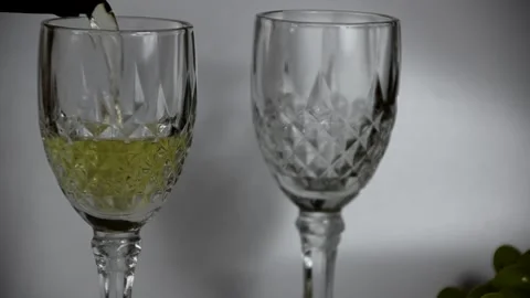 Pour white dry or semi-dry wine into glasses from a bottle Stockbeeldmateriaal 143612016