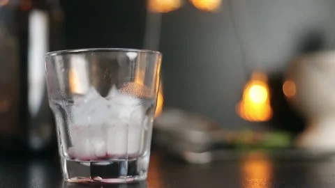 Poured into a glass with ice from a bottle, bartender, close-up Stock Footage 137789699