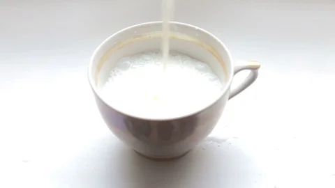 Is poured milk into the cup Stock Footage 72141249