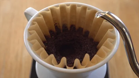 Pouring additional hot water over ground coffee beans during the process of Stock Footage 93241882