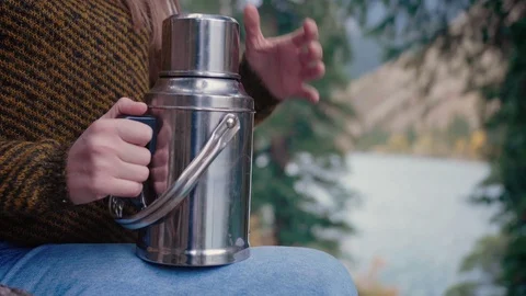 Pouring and drinking hot tea or thermos beverage enjoying taste in forest lake Stock Footage 104089663