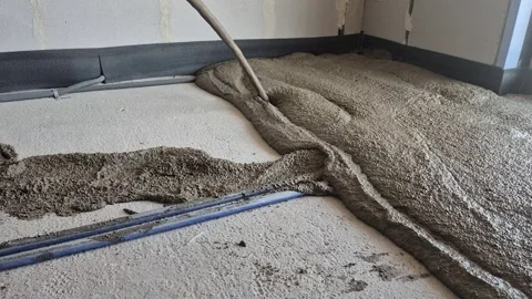 Pouring and spreading lightweight polystyrene concrete over floor heating pipes Stock Footage 341510063