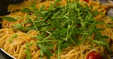 Pouring arugula in Pasta Spaghetti in Pan Slow motion 4K Stock Footage 104051752