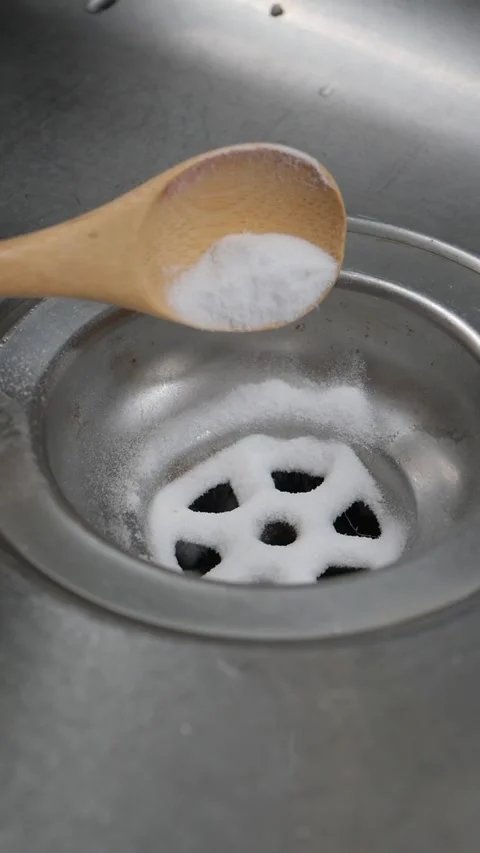 Pouring baking soda powder into the kitchen sink for cleaning Stock Footage 336981639